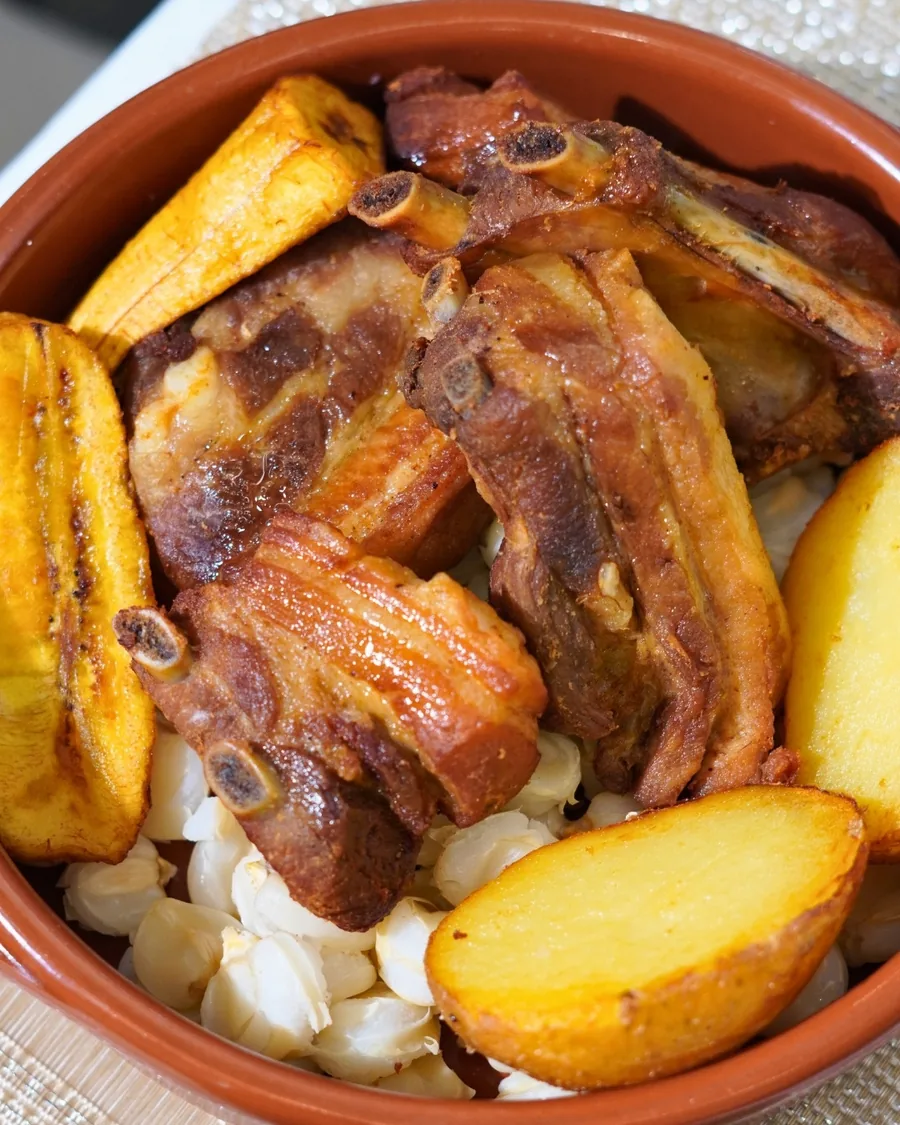 Fried pork ribs with hominy, plantain and potato