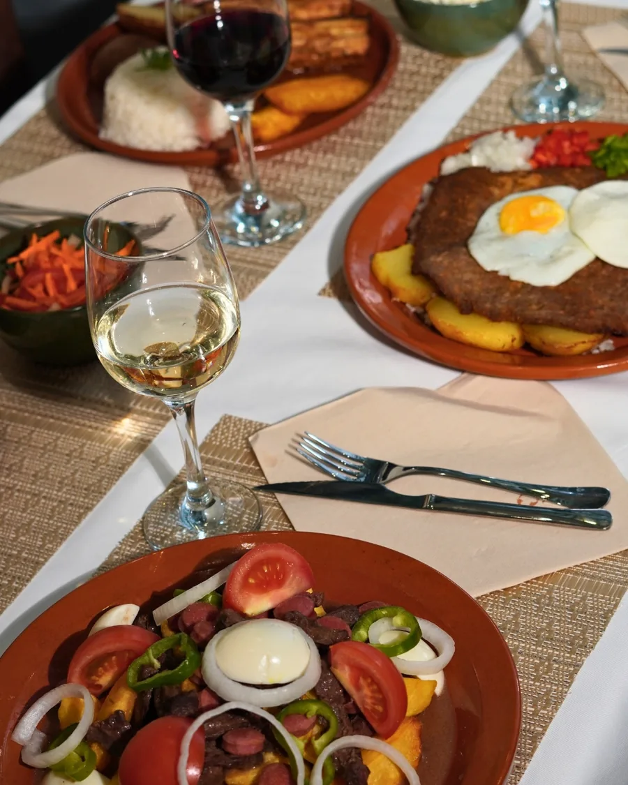 Pique macho, with tomato, onion, pepper and boiled egg, next to a glass of white wine