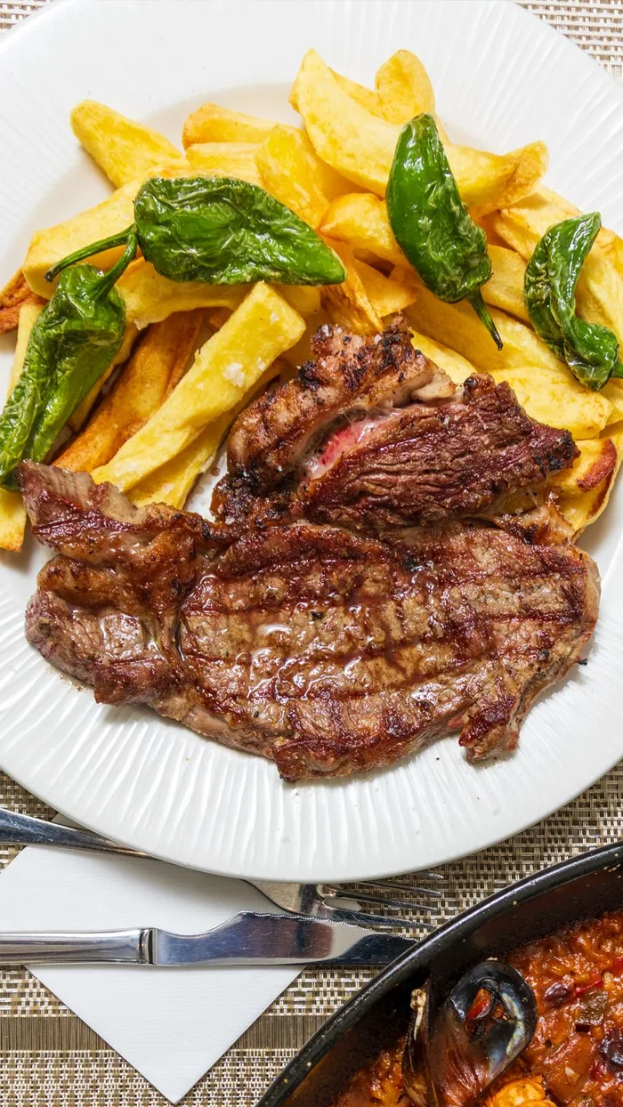 Entrecot a la brasa con patatas fritas y pimientos de Padrón