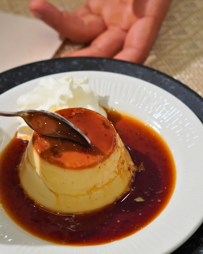 Un flan casero con caramelo, con la cuchara dentro