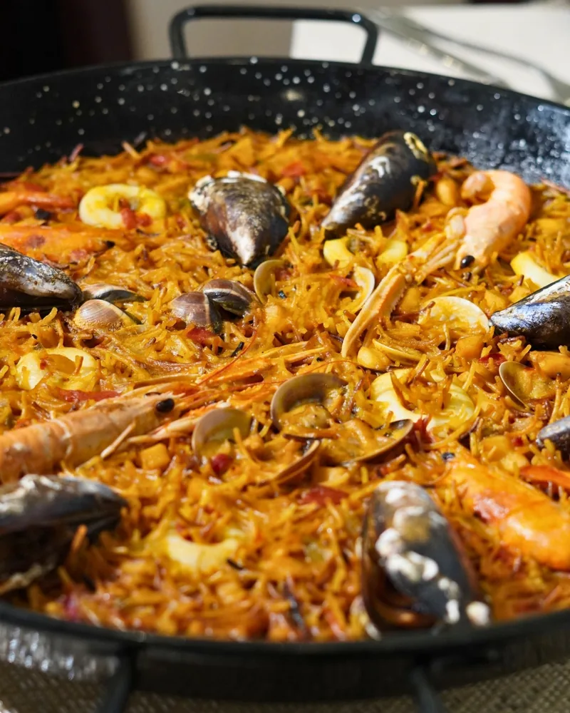 Una fideuá de marisco de cerca, con mejillones, almejas y cigalas