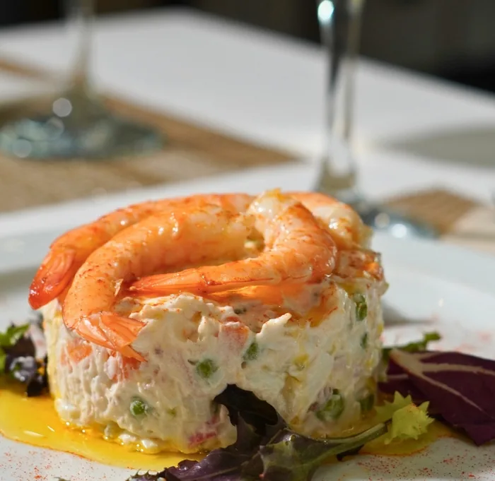 Una ensaladilla rusa coronada con langostinos